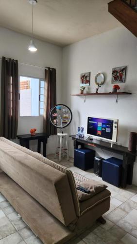 a living room with a couch and a television at Casa da Praia - Casa em Arraial do Cabo - Monte Alto - Região dos Lagos - RJ in Arraial do Cabo