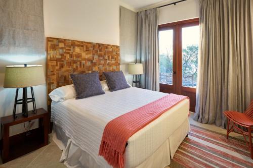 een hotelkamer met een bed en een raam bij Las Catalinas - Beachfront GUESTHOUSE for 6 persons - Alouatta Guesthouse in Playa Danta