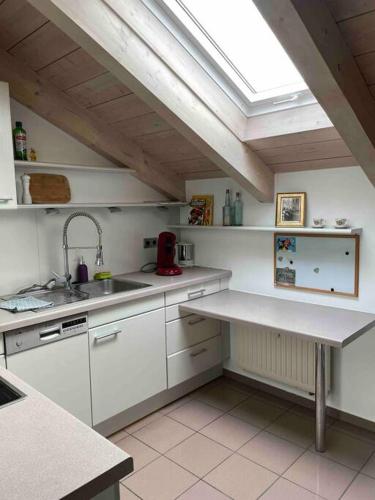 a kitchen with white cabinets and a skylight at Zweite Heimat in Mühldorf in Mühldorf
