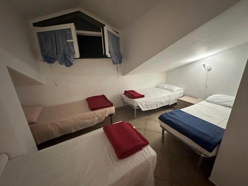 a small room with two beds and a window at La Quercia Fiorita in Trivolzio