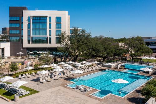 uma vista superior para uma piscina com cadeiras e guarda-sóis em Drey Hotel em Dallas