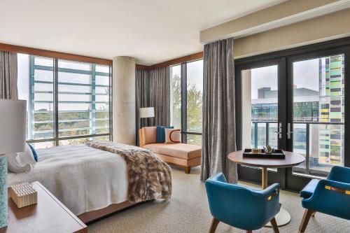 Drey Hotel في دالاس: غرفة فندقية بسرير وطاولة وكراسي