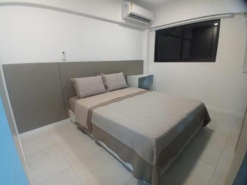 ein kleines Schlafzimmer mit einem Bett und einem Fernseher in der Unterkunft Flat Por Temporada no Edifício Time Maceió-AL in Maceió