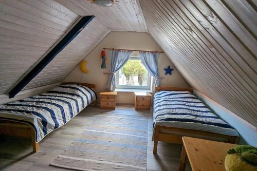 een slaapkamer op zolder met 2 bedden en een raam bij Möwennest Meldorf in Meldorf