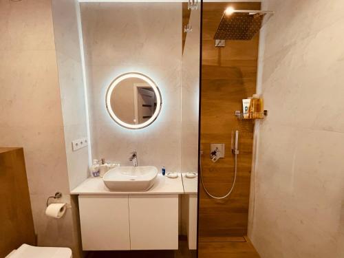 a bathroom with a sink and a shower at Apartamenty KTW Park Śląski Bytkowska 103A in Katowice