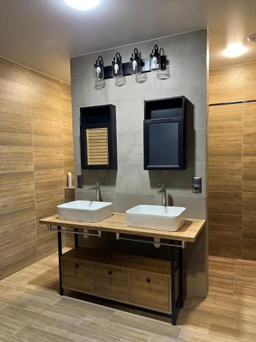 a bathroom with two sinks and a flat screen tv at Cristal Apartament in Tiraspol