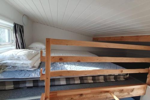 Nyhem stugan في Våxtorp: غرفة نوم مع سريرين بطابقين في منزل