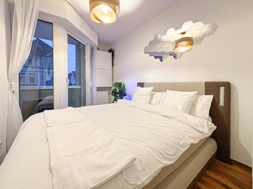 1 dormitorio con 1 cama blanca grande y ventana en Luxurious Apartment in City-Center with Balcony, Free Parking, en Bielefeld