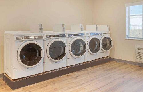 a laundry room with three washing machines in it at Extended Stay America Suites - Baytown in Baytown