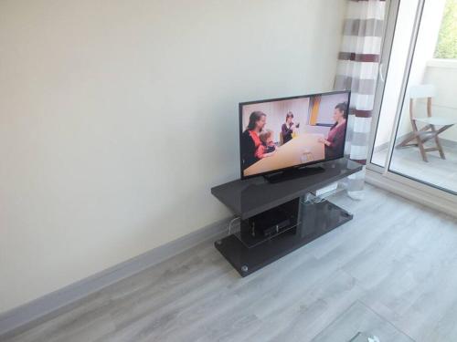 a flat screen tv sitting on a stand in a living room at LE GREY-JARDIN DES PLANTES-CENTRE DES CONGRES in Angers