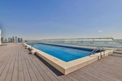 a swimming pool on a boardwalk next to the ocean at studio apartment 60 sqm skyline veiw in Dubai