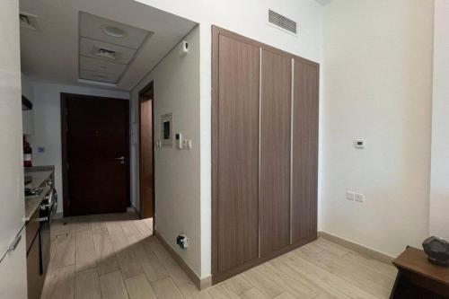 a hallway with a wooden door in a room at studio apartment 60 sqm skyline veiw in Dubai