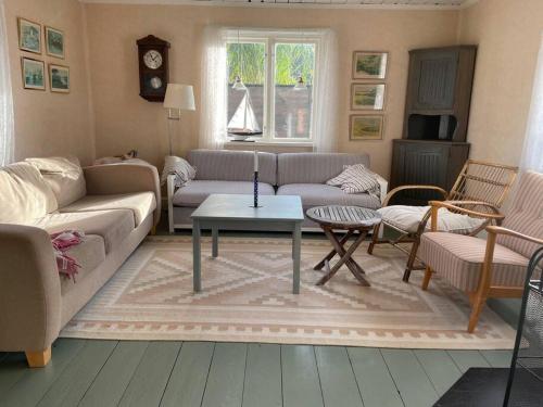 a living room with a couch and a table at Idylliskt hus med havsutsikt in Sölvesborg