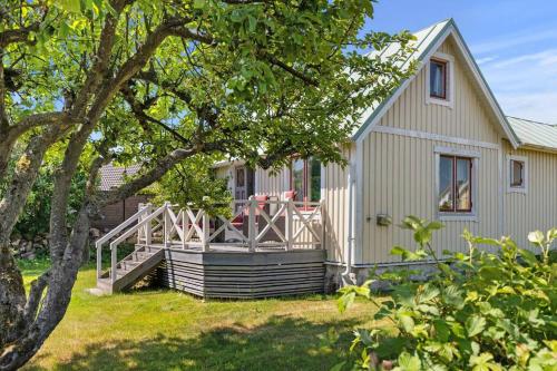 a white house with a porch and a deck at Idylliskt hus med havsutsikt in Sölvesborg