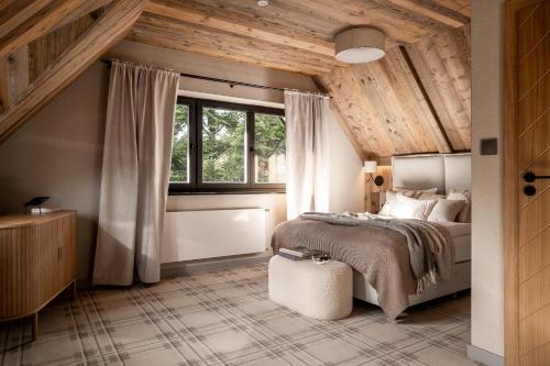 sypialnia z dużym łóżkiem i oknem w obiekcie Chalet V11 by Villa 11 Folk & Design w Zakopanem