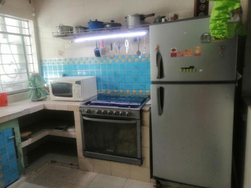 a kitchen with a refrigerator and a microwave at Casa céntrica antigua completa in Orizaba