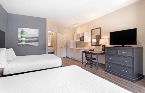 um quarto de hotel com duas camas e uma secretária com uma televisão em Extended Stay America Suites - Baytown em Baytown
