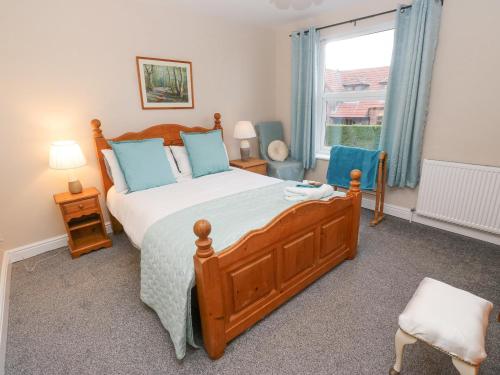 a bedroom with a large wooden bed with blue pillows at Bluebell Cottage in Selby