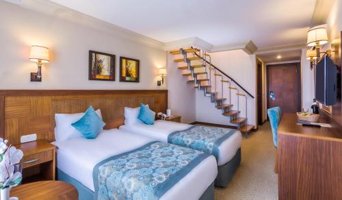 a hotel room with two beds and a staircase at Villa Side Hotel in Side