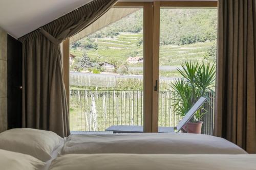 1 dormitorio con cama y ventana grande en Apartsuites Rosengarten - New en Lagundo