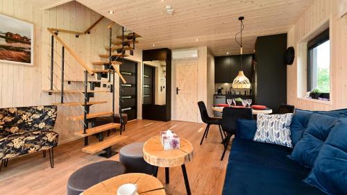 ein Wohnzimmer mit einem blauen Sofa und einem Tisch in der Unterkunft Lawendowe Domki Latoszyn-Zdrój Domek Bergen in Latoszyn
