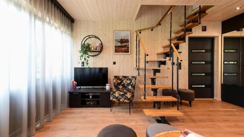 ein Wohnzimmer mit einer Wendeltreppe und einem Schreibtisch in der Unterkunft Lawendowe Domki Latoszyn-Zdrój Domek Bergen in Latoszyn