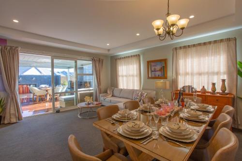 un soggiorno con tavolo da pranzo e sedie di Luxury Spa, Outdoor Fireplace & Games Room - Sleeps 10, 18 mins from CHC Airport a Prebbleton