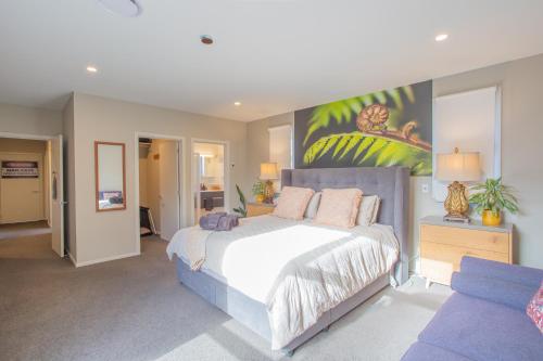 una camera da letto con un letto e un quadro sul muro di Luxury Spa, Outdoor Fireplace & Games Room - Sleeps 10, 18 mins from CHC Airport a Prebbleton