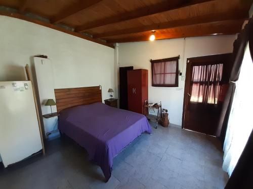 1 dormitorio con 1 cama de color púrpura en una habitación en Alquileres en san miguel del monte en San Miguel del Monte