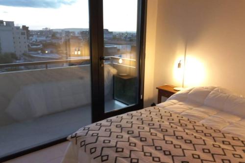 Schlafzimmer mit einem Bett und einem Fenster mit Aussicht in der Unterkunft Espectacular departamento con inigualables vistas in Balcarce