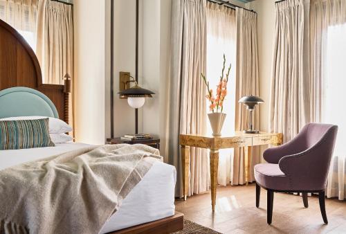 a bedroom with a bed and a desk and a chair at Zelda Dearest in Asheville