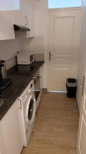 une cuisine avec un lave-linge et une porte dans l'établissement Appartement T2 à 35min de Paris & 20min de Disney à Saint Jean, à Saint-Jean-les-Deux-Jumeaux