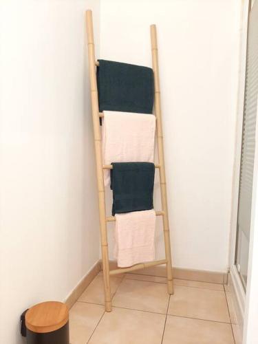 a towel rack with four towels on a wall at Proche aéroport à pied, Le Rêve Rose. in Tillé