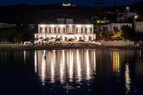 un edificio blanco con luces en el agua por la noche en Emily Hotel en Vári