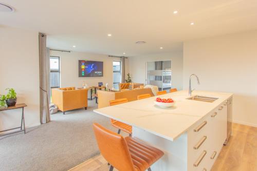 a kitchen and living room with a counter and chairs at New Luxury Home with Games Room and Park Outlook Sleeps 12, 26 mins from CHC airport in Lincoln