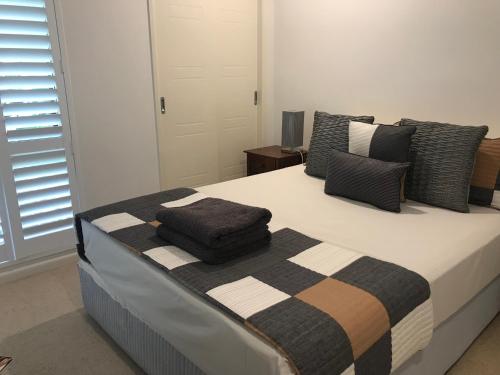 a bedroom with a large bed with pillows on it at Chez Brolga in Port Douglas