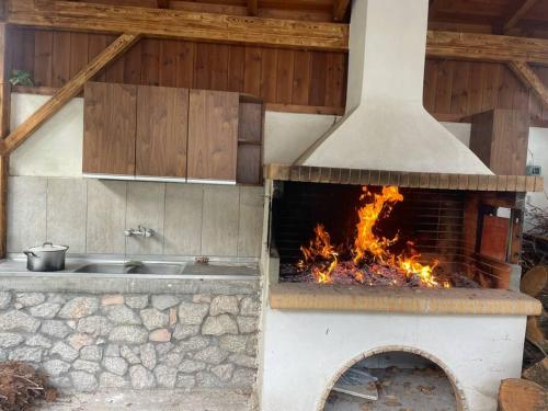 een pizza-oven in de buitenlucht met een open haard bij Gravia's Villa in Graviá