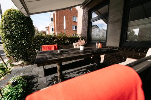 a wooden table and chairs on a patio at INSIDE Nordhorn by Hackmann in Nordhorn