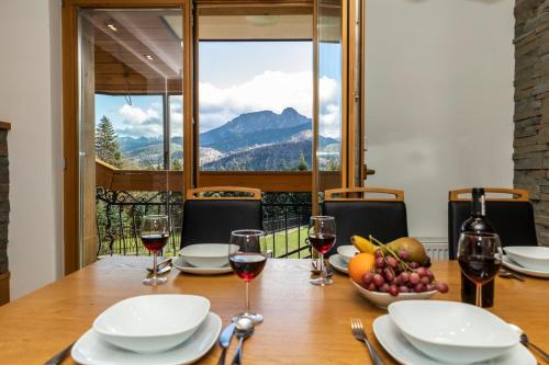 a table with glasses of wine and a bowl of fruit at Mountain Base - Rezydencja Górski Potok Premium in Kościelisko