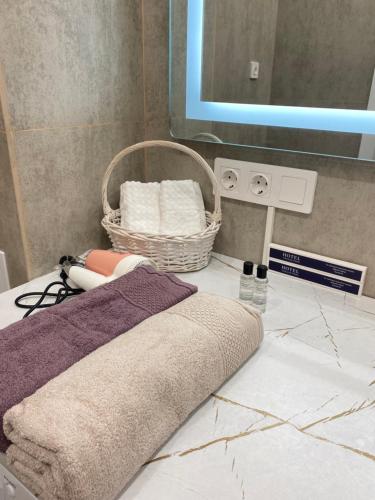 ein Badezimmer mit einer Theke mit Handtüchern und einem Spiegel in der Unterkunft ЖК Homeland EXPO 1 комн in Taldykolʼ