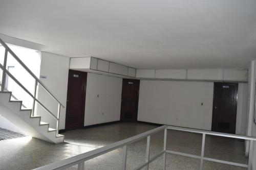 an empty room with stairs and doors in a building at Gran Hotel Caravana in Cúcuta