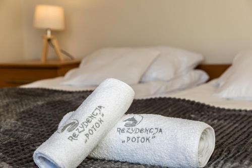 a roll of toilet paper sitting on a bed at Mountain Base - Rezydencja Górski Potok Premium in Kościelisko
