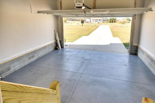 an empty garage with a door open to a field at Cape Charles Home 4 Mi to Kiptopeke State Park! in Cape Charles