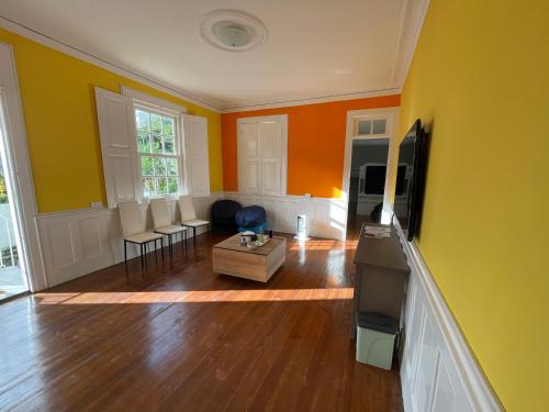a living room with yellow and orange walls at Owls Hostel Ildefonso in Porto