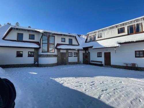 a snow covered yard in front of a building at Penzión Hruboš in Habovka