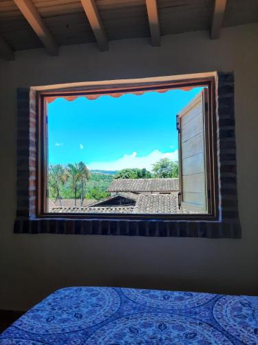 a bedroom with a window with a view of a house at Apartamento El trigal in Barichara