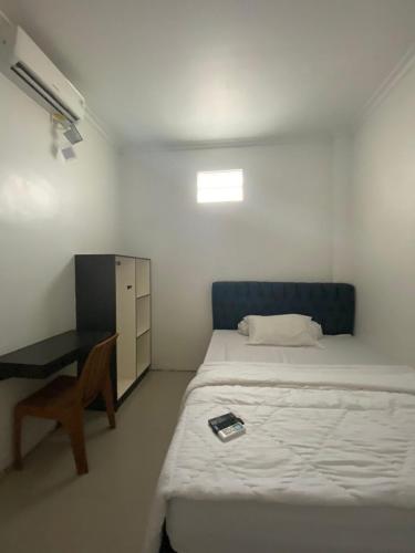 Pondok Gramada 2 في تْشيريبون: غرفة نوم صغيرة مع سرير ومكتب