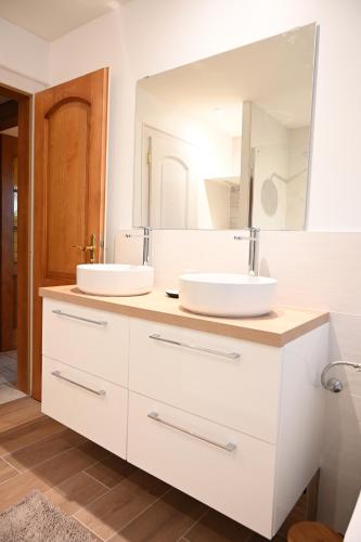 a bathroom with two sinks and a large mirror at Gîte l'Avant in Rouffach