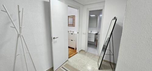 Baño blanco con espejo y lavabo en Apartamento Gómez en Caravaca de la Cruz