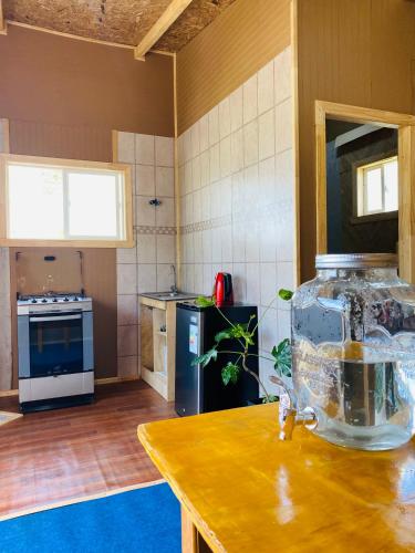 a kitchen with a fish bowl on a wooden table at Tiny house in Ancud